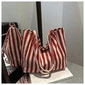 Red and white striped canvas tote bag with magnetic closure on a clean book surface - Red