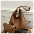 Dettaglio di una borsa tote in pelle marrone con pochette coordinata in un set moderno - Marrone scuro