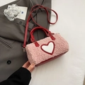 Rosa Plüsch-Henkeltasche mit rotem Herz-Patch und Lederriemen auf grauem Sakko - Rosa