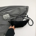 Minimalistische schwarze Wildleder-Halbmondtasche mit geknotetem Gurt und matter Optik - Schwarz