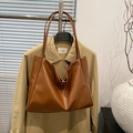 Bolso tote minimalista en cuero marrón con correas finas y textura suave al tacto - Marrón