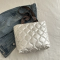 Silver quilted tote bag with ethnic pattern straps on casual denim background - White