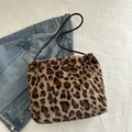 Faux fur leopard print tote bag with black shoulder straps on denim background - Brown