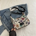 Minimalist canvas shoulder bag featuring a colorful floral jacquard pattern and black strap - Black