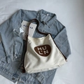 Minimalistische witte canvas draagtas met bruine logo-patch en bijpassende hengsels - Off-wit