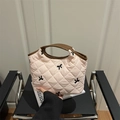 Bolso acolchado rosa con bordado de lazo negro y asas de cuero marrón en una silla - Rosa