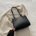Sac cabas élégant en cuir noir avec un détail nœud argenté sur un blazer ivoire - Noir