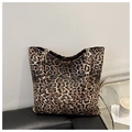 Leopard print tote bag with dual straps placed on a black bench for a stylish urban look - Brown