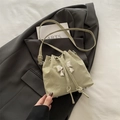 Chic light green drawstring bucket bag featuring a silver bow metal accent and pleated texture - Green