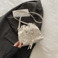 Chic white pleated bucket bag featuring a silver metal bow and drawstring closure - White