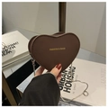 Detail einer herzförmigen Mini-Tasche aus braunem Leder mit silberner Metallkette - Braun