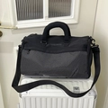 Große schwarze Sport- Reisetasche mit Karomuster auf einem weißen Reisekoffer - Schwarz