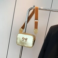 Golden bow crossbody bag with a metallic finish and wide orange fabric strap - Gold