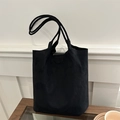Retro black matte suede tote bag with long double shoulder straps on a glass table - Black