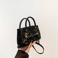 Minimalist black wrinkled patent leather handbag with elegant gold hardware accents - Black