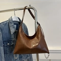 Minimalistische dunkelbraune Ledertasche mit geometrischem Patchwork und silbernen Ketten - Braun
