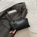 Bolso tote negro minimalista de cuero sintético mate sobre una chaqueta gris - Negro