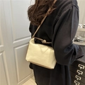 Minimalistische beige Plissee-Schultertasche mit braunem Lederbesatz und Trageriemen - Gebrochenes Weiß