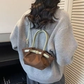 Sac à main vintage en daim marron et vert porté par un mannequin en pull gris chic - Café et Vert