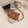 Borsa a mano marrone in pelle con chiusura dorata su una scrivania minimalista - Marrone
