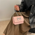 Mini-Umhängetasche in Rosa mit silberner Schleife und Kettenriemen am Model - Rosa