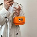 Mini orangefarbene Umhängetasche mit silberner Metallschleife und glänzendem Leder - Orange