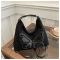 Detail of black bow-knot shoulder bag featuring vintage matte texture and long tassels - Black
