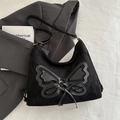 Black faux suede shoulder bag with a large leather bow patch and adjustable strap - Black
