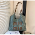Nahaufnahme der gewaschenen Segeltuch-Tasche in Petrol mit braunen Ledergriffen und Logo - Denim-Blau