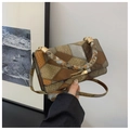 Gros plan d'un sac à main rétro en patchwork avec poignée tressée et détails dorés - Marron