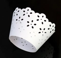 Detailed laser-cut white cupcake wrappers with elegant floral patterns and scalloped edges - White
