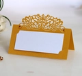 Detail of laser-cut gold wedding place card with elegant lace pattern and blank name area - Gold
