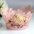 Detailed macro view of laser-cut pink paper cupcake liners with elegant floral patterns - Pink