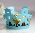 Makro-Detail von hellblauer Laser-Cupcake-Hülle mit süßem Bären- und Herzmuster-Design - Tiffany Blau