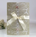Dettaglio dell'invito dorato tagliato a laser con fiocco in raso e inserto floreale - Oro Chiaro Glitter