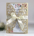 Elegant laser-cut wedding invitation in dark blue with a cream silk bow and floral insert - Beige Gold