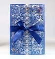 Detail of laser-cut royal blue lace wedding invitation with glitter finish and satin bow - Glitter Royal Blue