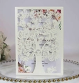 Close-up of laser-cut ivory tree and bird invitation card with floral interior insert - Ivory