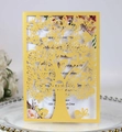 Detail of yellow laser-cut invitation card with intricate tree and butterfly patterns - Gold