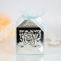 Close-up of laser-cut silver rose wedding favor box with a light blue organza ribbon bow - Reflective Silver