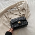 Borsa a tracolla trapuntata nera con catena dorata e chiusura a scatto su blazer beige - Nero