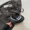 Bolso bandolera de media luna negro en cuero sintético brillante con herrajes plateados - Negro