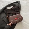 Dark brown leather crossbody bag with red cherry charm and wavy stitching details - Brown