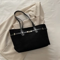 Large black suede tote bag with gold ring buckle and long straps on beige blazer - Black