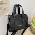 Elegante schwarze Handtasche aus Ölleder mit goldener Aufschrift und verstellbarem Gurt - Schwarz
