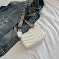 Weiße gesteppte Umhängetasche mit geometrischem Schultergurt auf einer Jeansjacke - Weiß