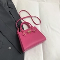 Schicke rosarote Handtasche aus Leder mit goldenen Elementen und sicherem Drehverschluss - Rosarot