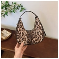 Detail of leopard print crescent bag on a wooden table with green plants for vintage style - Coffee