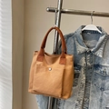 Minimalistische Canvas-Tragetasche in Khaki mit dunkelbraunen Griffen und Metallknopf - Braun