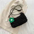 Minimalist black quilted shoulder bag with textured plissé finish and floral charm detail - Black